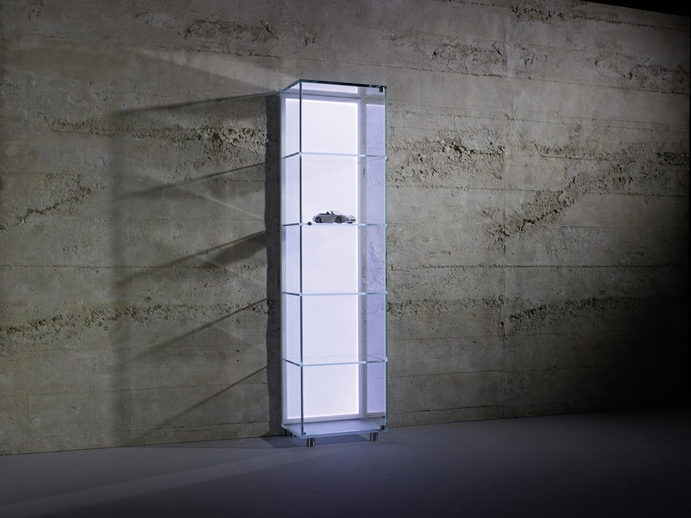 Beleuchtete SOLUS BACKLIGHT Glasvitrine vor einer dunklen Betonwand